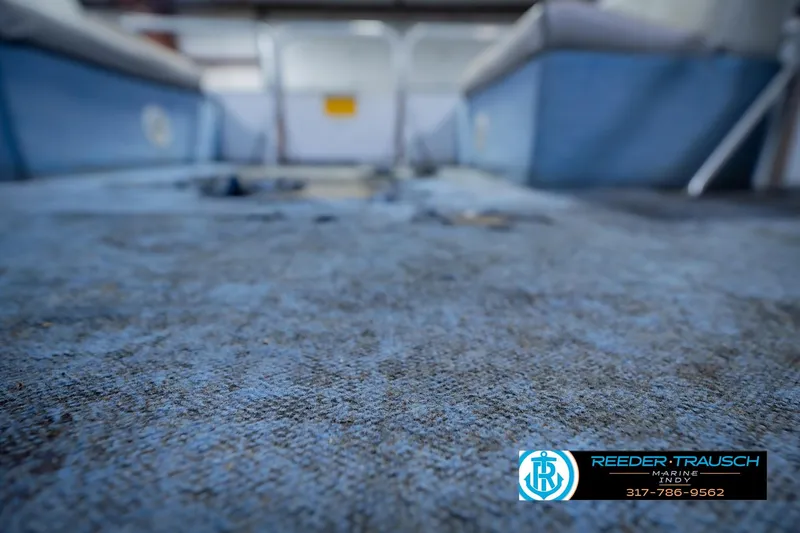 Slide: The Image of Worn interior carpet of a 1993 Godfrey SW 180 boat, with visible seating. - 39