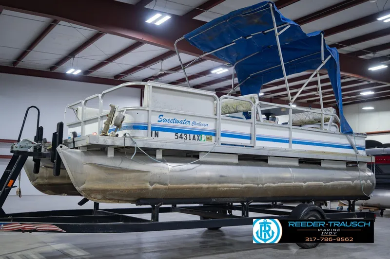 Slide: The Image of 1993 Godfrey SW 180 pontoon boat with blue canopy on trailer in indoor storage. - 4