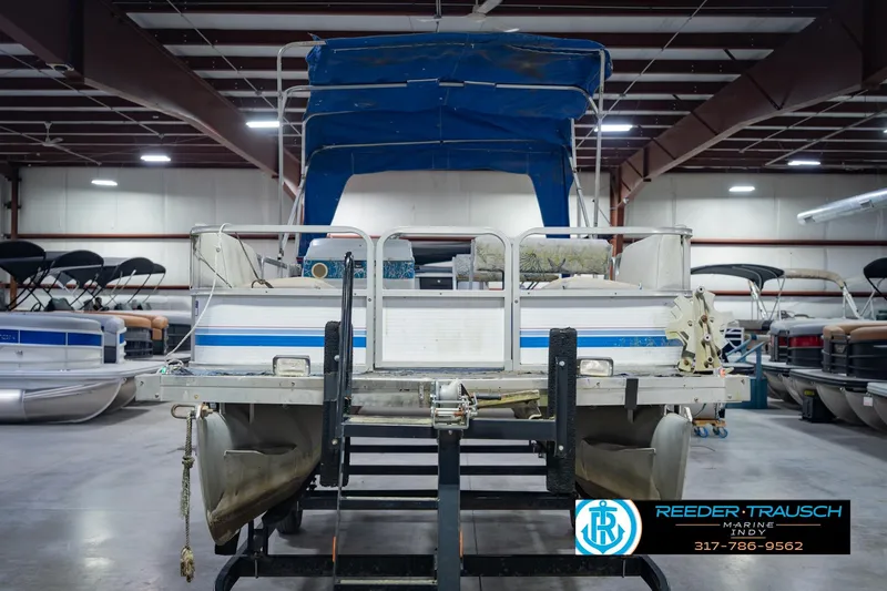 Slide: The Image of 1993 Godfrey SW 180 pontoon boat in indoor storage, featuring blue canopy. - 5