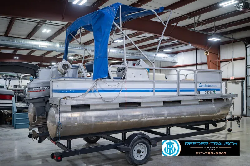 Slide: The Image of 1993 Godfrey SW 180 pontoon boat with blue canopy in indoor storage facility. - 8