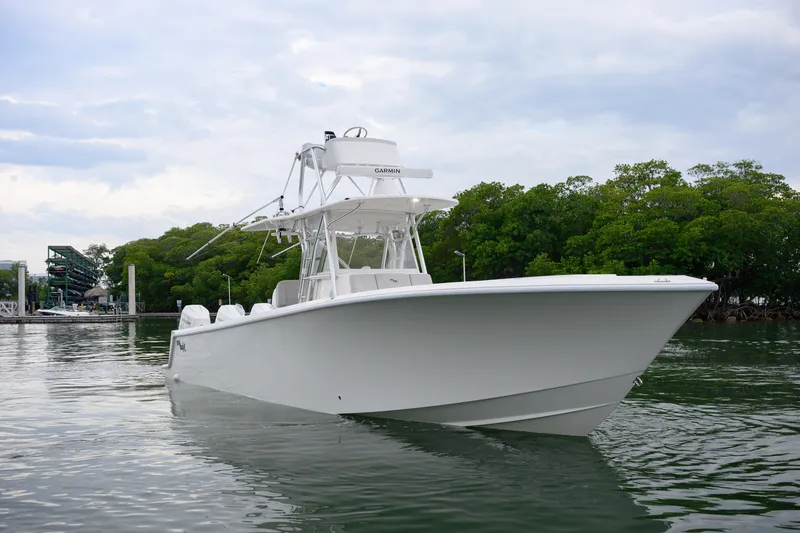 The Image of 2025 SeaVee 370Z boat on calm water near lush green trees. - 1