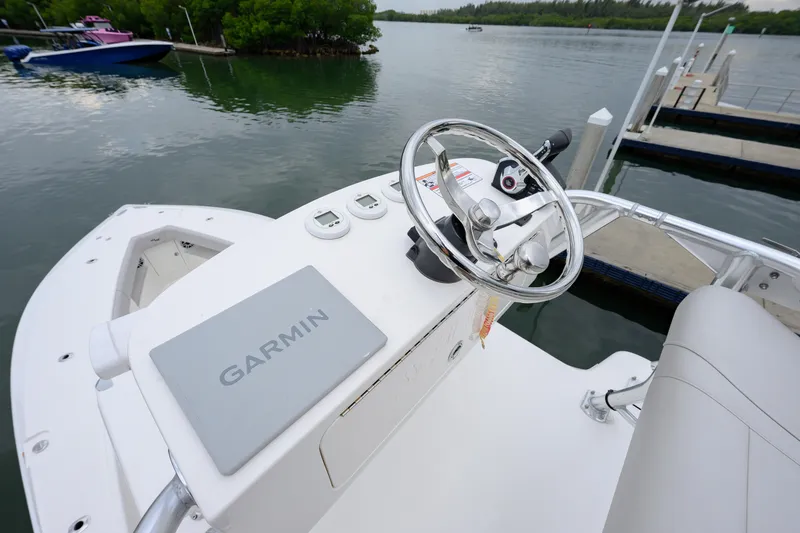 Slide: The Image of 2025 SeaVee 370Z boat helm with Garmin navigation, docked by calm waters. - 11