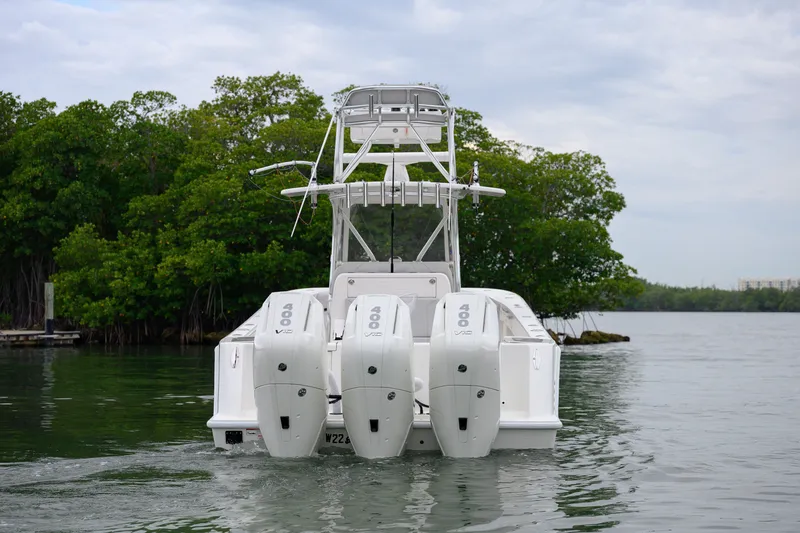 Slide: The Image of 2025 SeaVee 370Z boat with triple 400 HP engines on a calm waterway. - 2