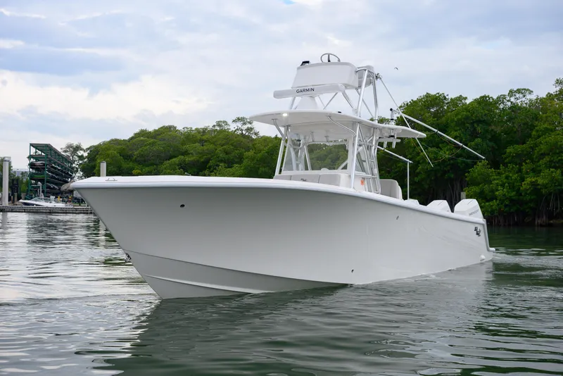 Slide: The Image of 2025 SeaVee 370Z boat on calm water, surrounded by lush greenery. - 3