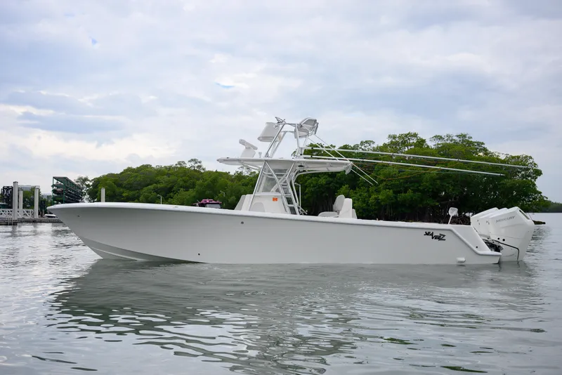 Slide: The Image of 2025 SeaVee 370Z boat on calm water, surrounded by lush greenery. - 4