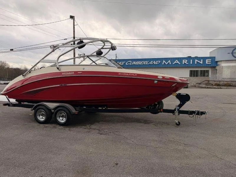 Slide: The Image of Red 2014 Yamaha 242 Limited S boat on trailer outside marine store. - 10
