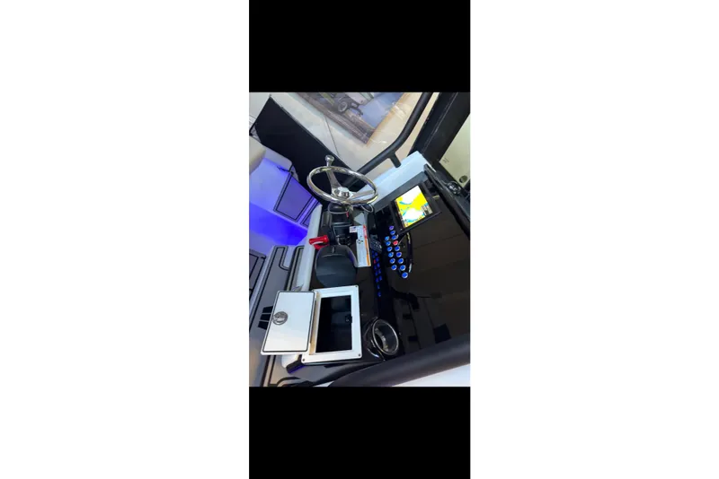 Slide: The Image of 2024 Wellcraft 223 Fisherman boat cockpit with modern steering and navigation system. - 4