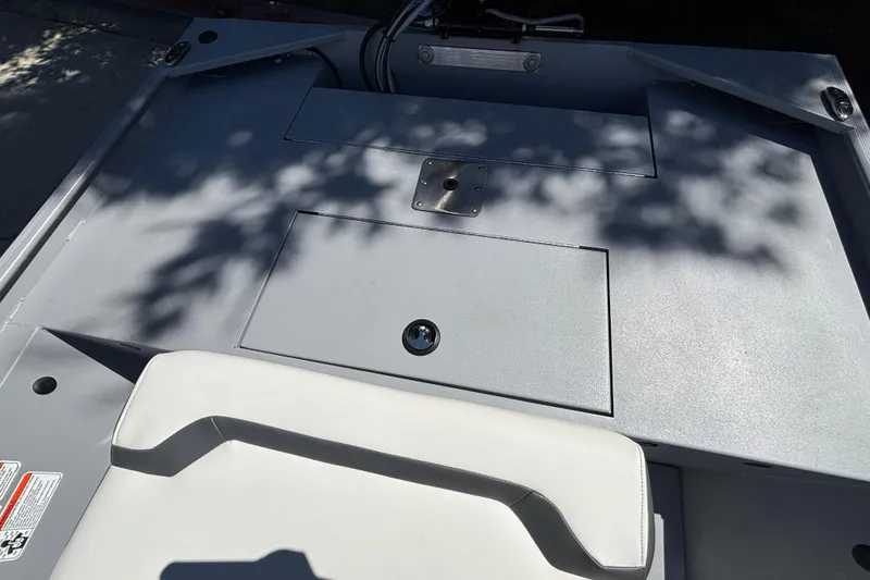 Slide: The Image of 2026 Tracker Bass Tracker Classic CC boat interior with storage compartment and seating. - 20