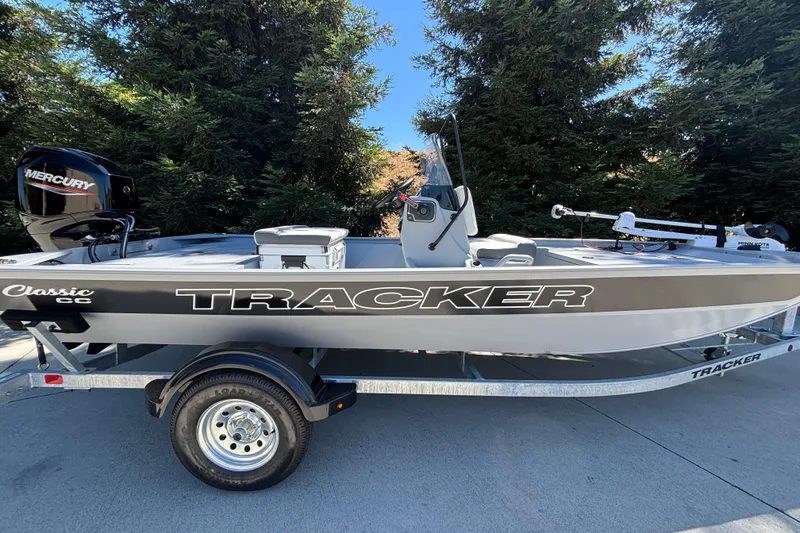 The Image of 2026 Tracker Bass Tracker Classic CC boat on trailer, featuring Mercury engine, parked outdoors. - 0