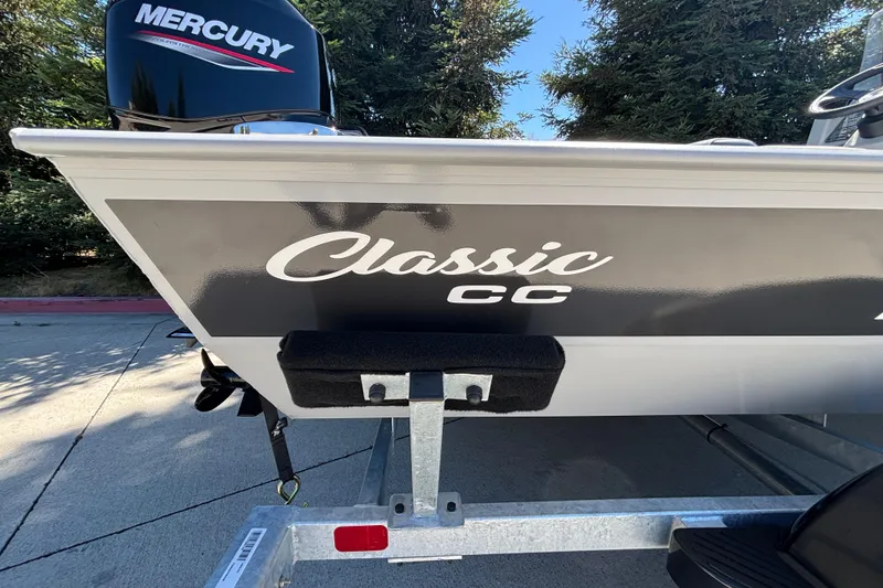 Slide: The Image of 2026 Tracker Bass Tracker Classic CC boat with Mercury engine, parked outdoors. - 10