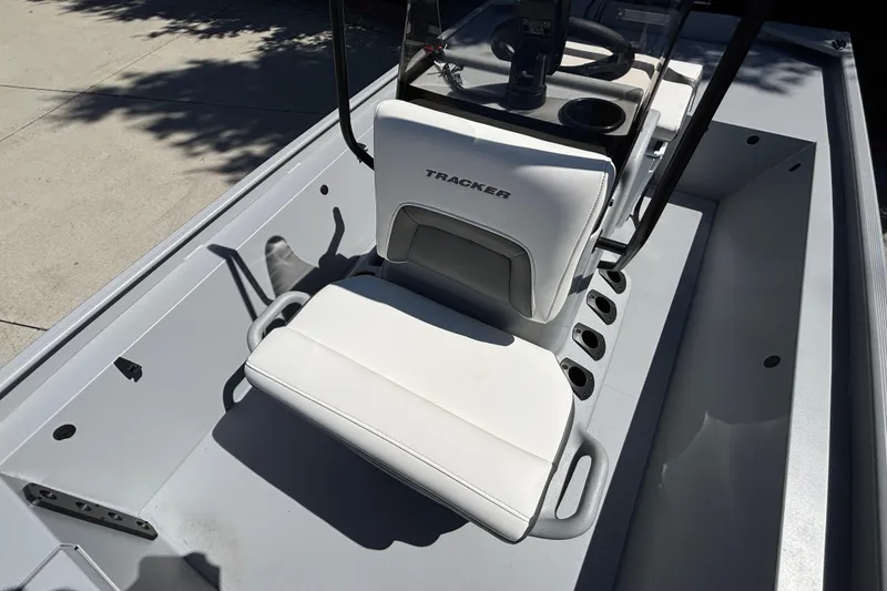 Slide: The Image of 2026 Tracker Bass Tracker Classic CC boat interior with white seating and steering console. - 27