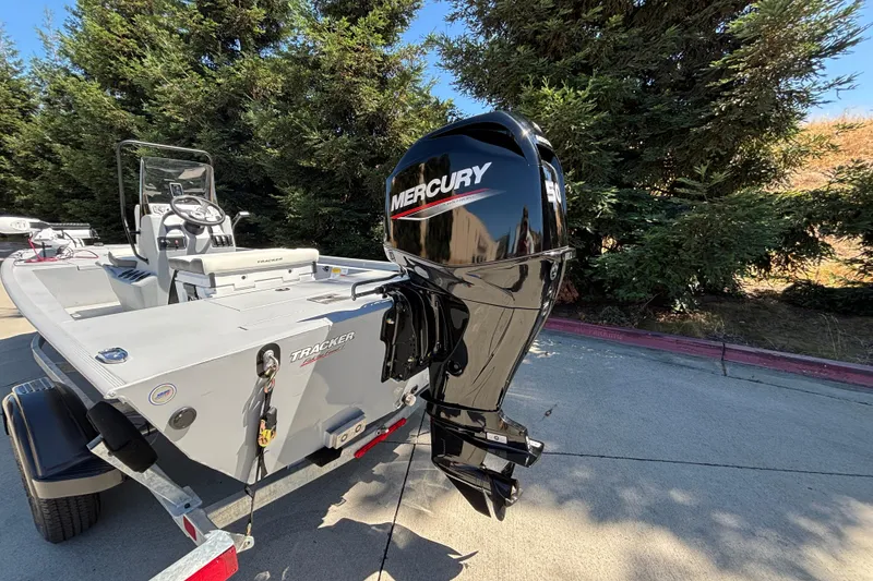Slide: The Image of 2026 Tracker Bass Tracker Classic CC boat with Mercury outboard motor, parked outdoors. - 13
