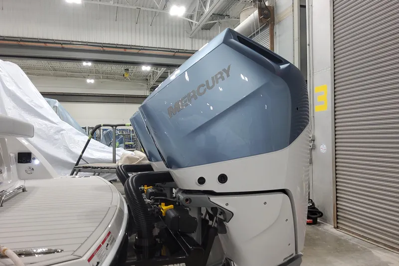 Slide: The Image of 2026 Formula 330 Crossover Bowrider OB with Mercury outboard engine in a garage. - 16