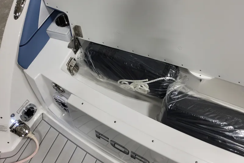 Slide: The Image of 2026 Formula 330 Crossover Bowrider OB storage compartment with wrapped cushions and rope. - 23