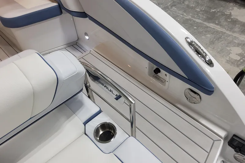 Slide: The Image of 2026 Formula 330 Crossover Bowrider OB interior with white and blue seating, cup holder, and branding. - 24