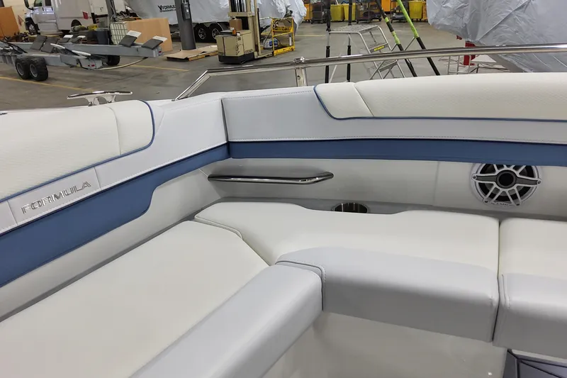 Slide: The Image of 2026 Formula 330 Crossover Bowrider OB interior with white and blue seating, speaker, and cup holder. - 30