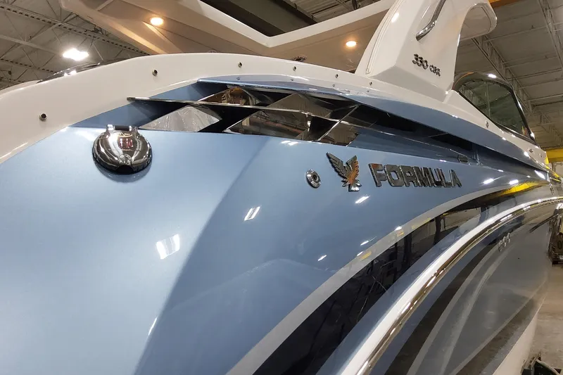 Slide: The Image of 2026 Formula 330 Crossover Bowrider OB in showroom, sleek blue exterior design. - 4