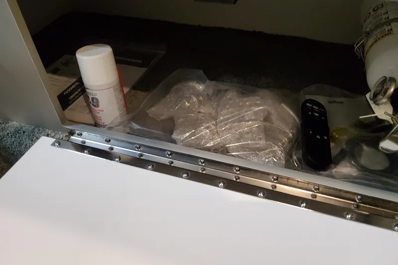 Slide: The Image of Storage compartment in a 2026 Formula 330 Crossover Bowrider OB with various items. - 50