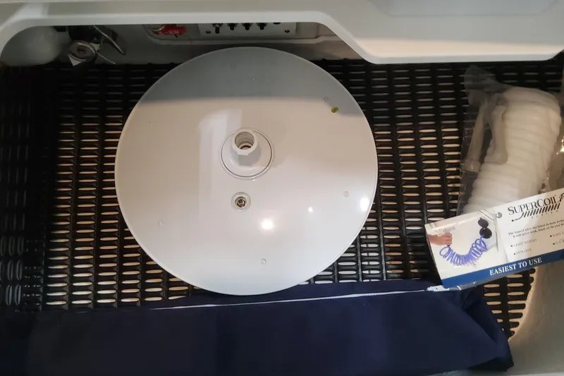 Slide: The Image of 2026 Formula 330 Crossover Bowrider OB storage compartment with accessories and coiled hose. - 72