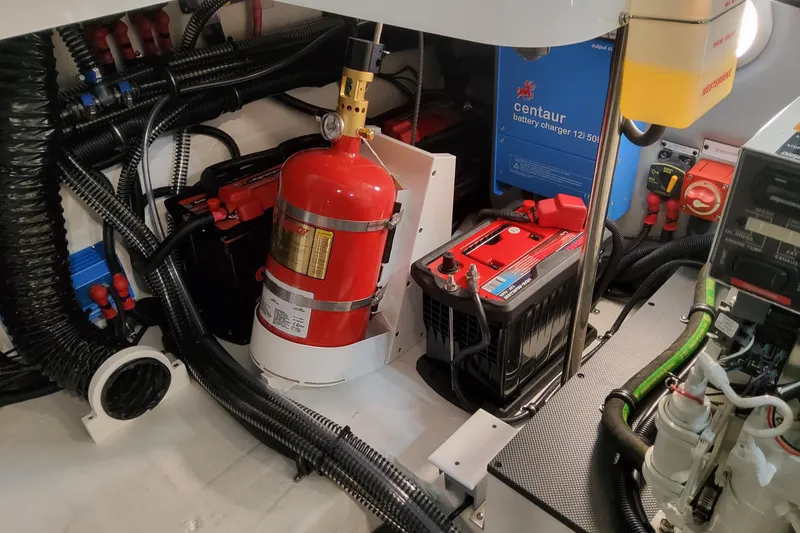 Slide: The Image of Engine compartment of 2026 Formula 330 Crossover Bowrider OB with fire extinguisher and battery charger. - 96