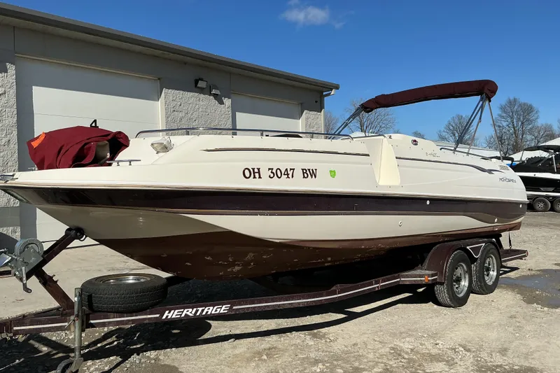 The Image of 1997 Monterey 233 Explorer boat on trailer, parked outdoors under clear blue sky. - 1