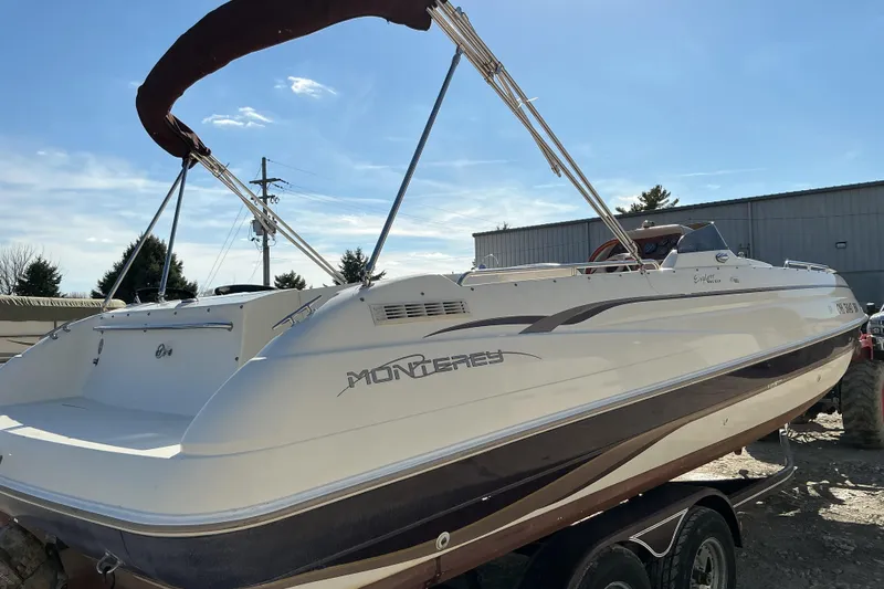 Slide: The Image of 1997 Monterey 233 Explorer boat on trailer, sunny day, outdoor setting. - 4