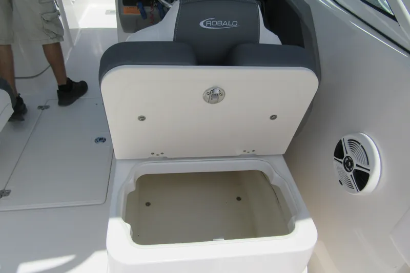 Slide: The Image of 2018 Robalo R247 Dual Console boat seat with storage compartment open. - 9