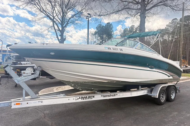 The Image of 2003 Sea Ray 240 Bow Rider on trailer, parked outdoors under a cloudy sky. - 0