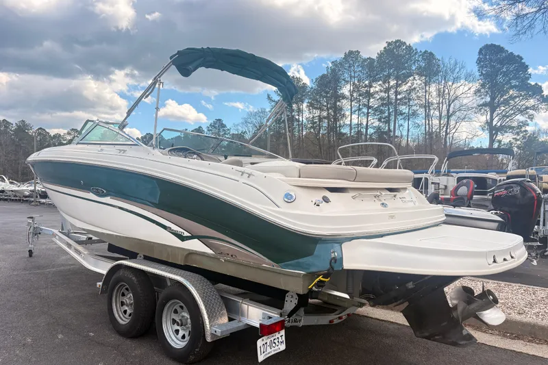 Slide: The Image of 2003 Sea Ray 240 Bow Rider boat on trailer, parked outdoors under cloudy sky. - 1
