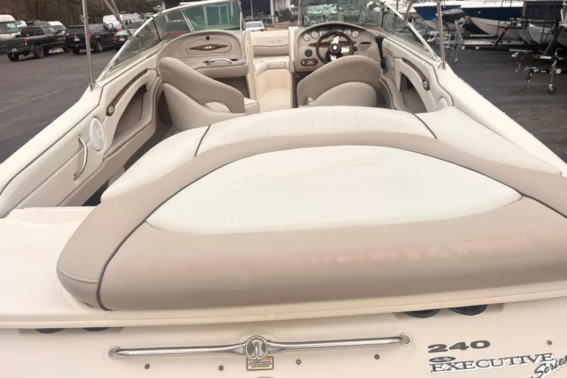Slide: The Image of 2003 Sea Ray 240 Bow Rider boat interior with beige seating and dashboard. - 11