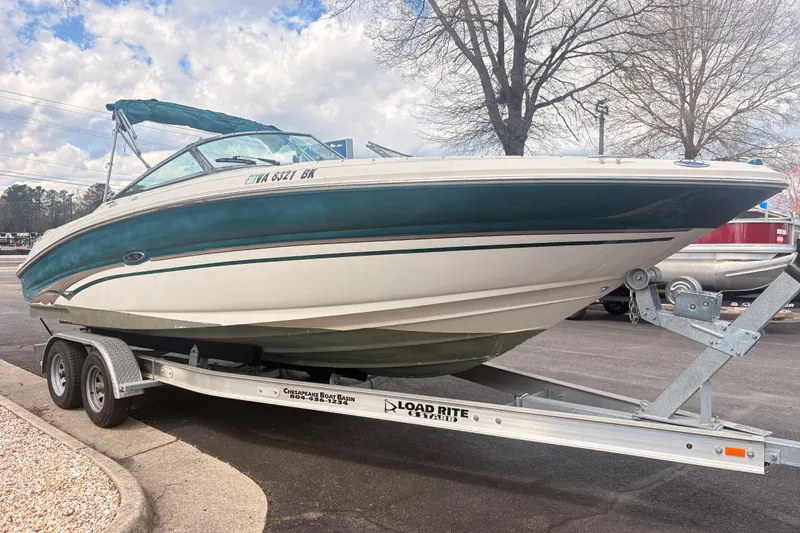 Slide: The Image of 2003 Sea Ray 240 Bow Rider on trailer, parked outdoors under cloudy sky. - 3