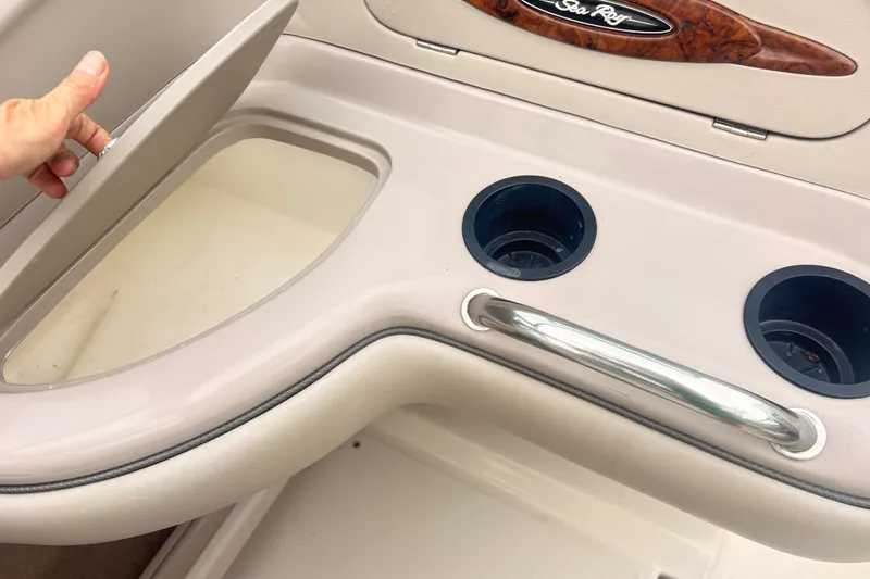 Slide: The Image of 2003 Sea Ray 240 Bow Rider interior with cup holders and storage compartment. - 8