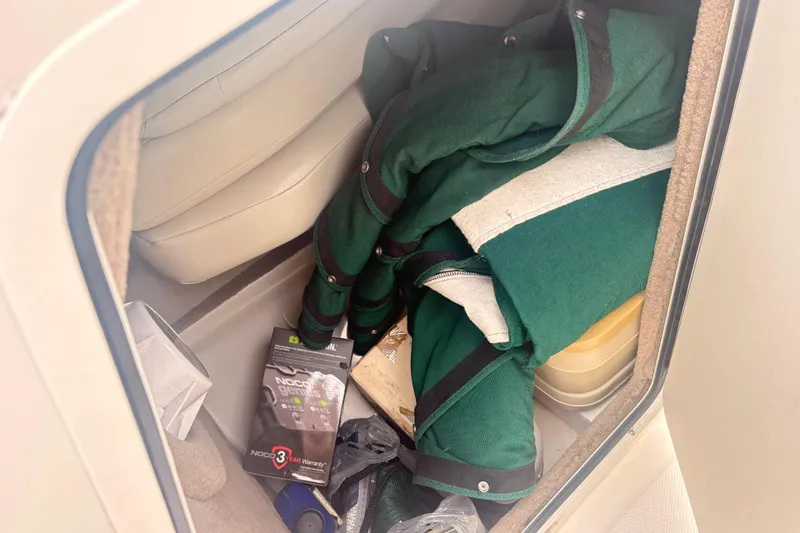 Slide: The Image of Storage compartment of a 2003 Sea Ray 240 Bow Rider with green covers and accessories. - 9