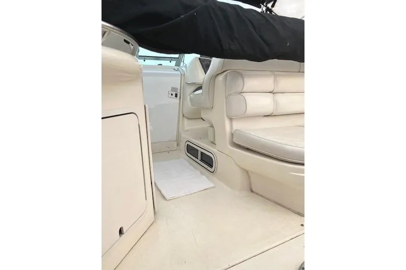 Slide: The Image of Interior of a 1996 Sea Ray Sundancer 330 boat, featuring beige seating and cabinetry. - 23