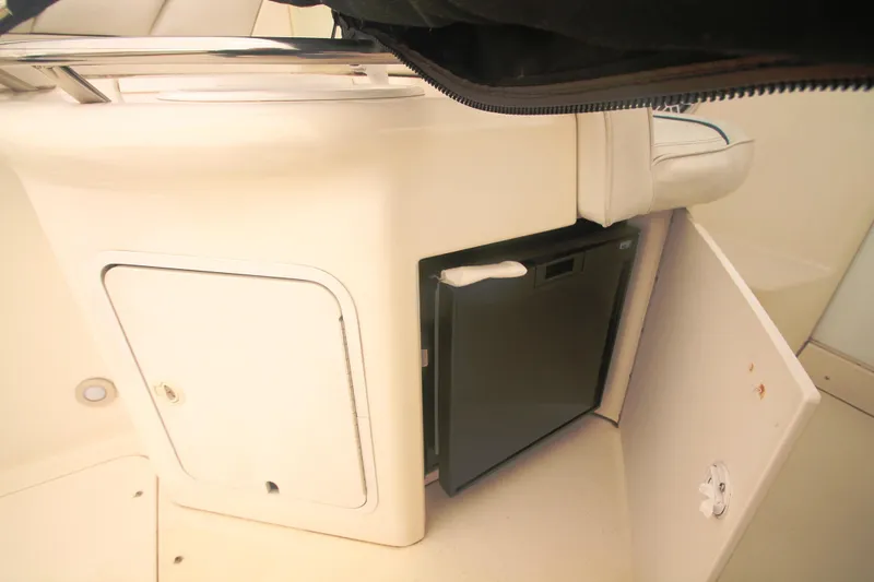 Slide: The Image of 1996 Sea Ray Sundancer 330 interior with mini fridge and storage compartment. - 33