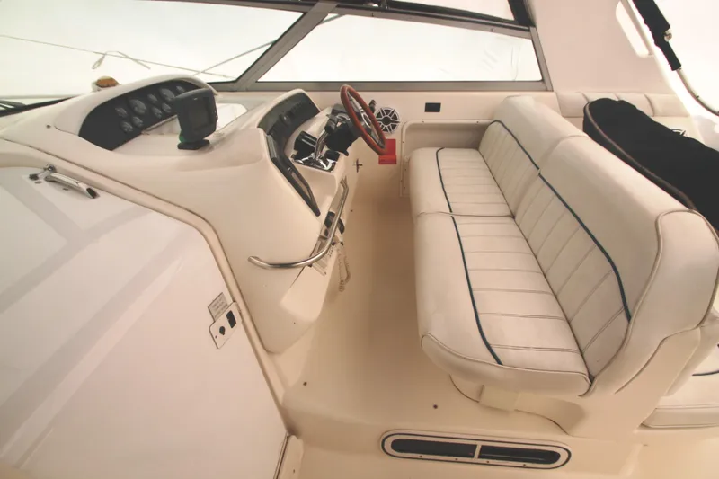 Slide: The Image of 1996 Sea Ray Sundancer 330 cockpit with white seating and steering wheel. - 36