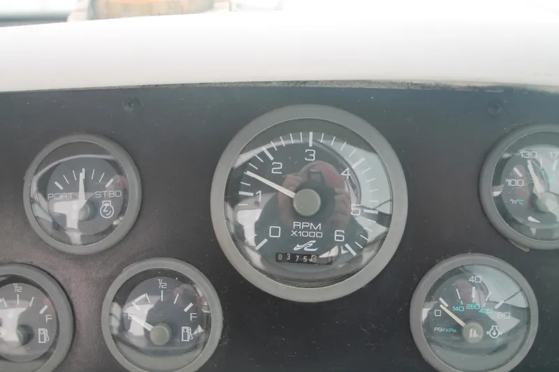 Slide: The Image of Dashboard gauges of a 1996 Sea Ray Sundancer 330 boat, showing RPM and fuel levels. - 48