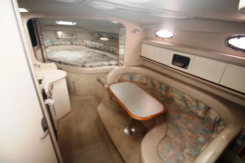 Slide: The Image of Interior of 1996 Sea Ray Sundancer 330, featuring cozy seating and compact kitchenette. - 5