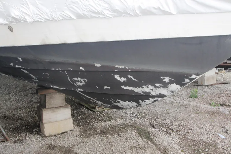 Slide: The Image of 1996 Sea Ray Sundancer 330 hull with peeling paint, supported on blocks. - 55