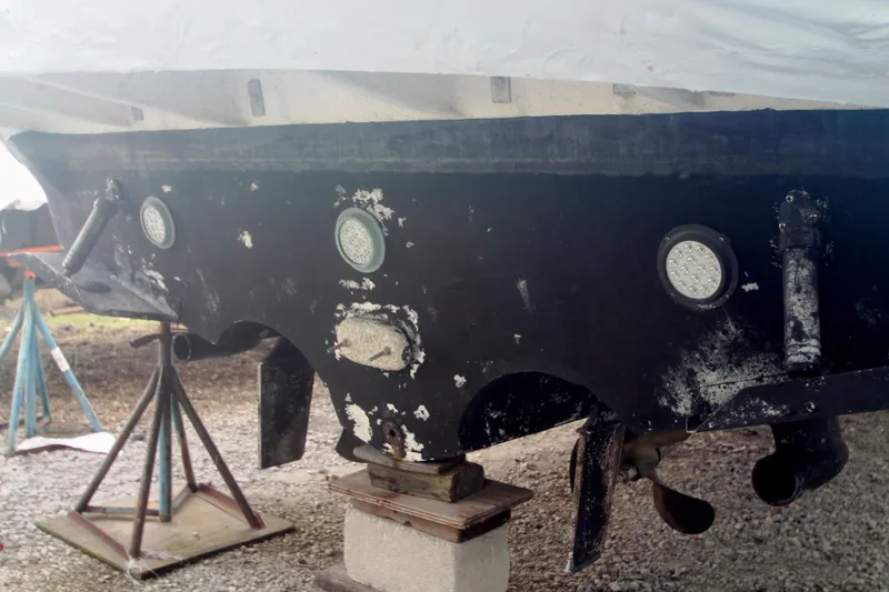 Slide: The Image of 1996 Sea Ray Sundancer 330 boat hull on stands, showing wear and propellers. - 56