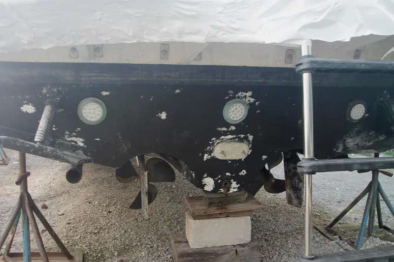 Slide: The Image of 1996 Sea Ray Sundancer 330 boat hull on stands, showing propellers and underwater lights. - 59