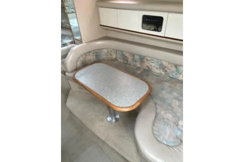 Slide: The Image of Interior of 1996 Sea Ray Sundancer 330 with cushioned seating and table. - 7