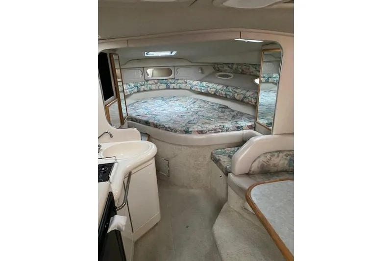 Slide: The Image of Interior of 1996 Sea Ray Sundancer 330, featuring a cozy cabin with a bed and kitchenette. - 9
