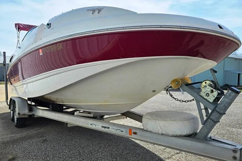 Slide: The Image of 2005 Chaparral Sunesta 254 boat on trailer, red and white hull, parked outdoors. - 13