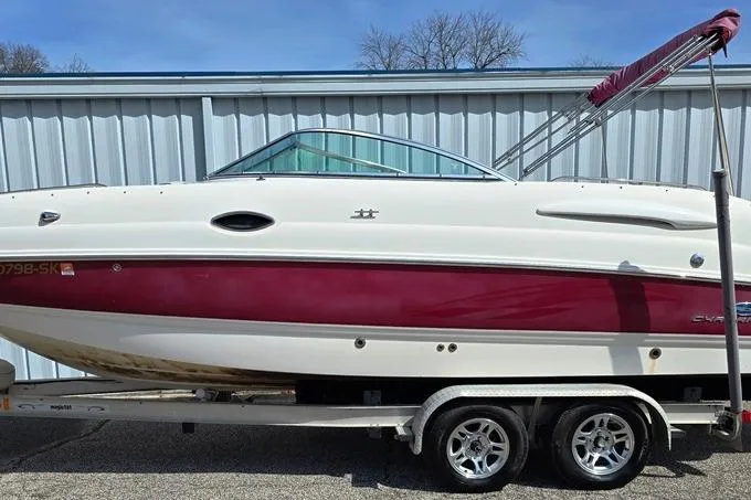 Slide: The Image of 2005 Chaparral Sunesta 254 boat on trailer, white and maroon, parked outdoors. - 27