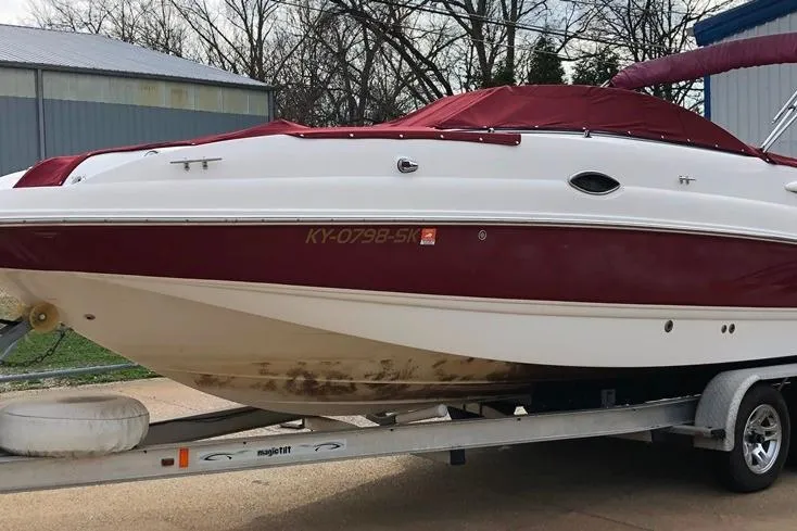 Slide: The Image of 2005 Chaparral Sunesta 254 boat on trailer with red cover, parked outdoors. - 28