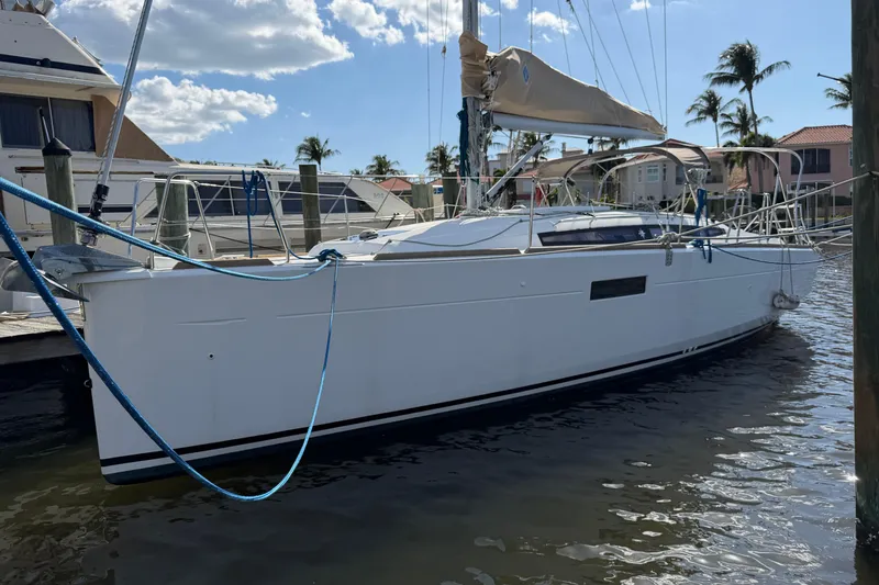 The Image of 2015 Jeanneau Sun Odyssey 349 sailboat docked at marina under blue sky. - 1