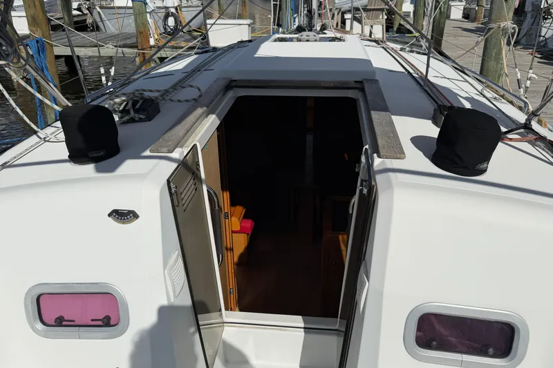 Slide: The Image of 2015 Jeanneau Sun Odyssey 349 sailboat cockpit with open cabin door at marina. - 13