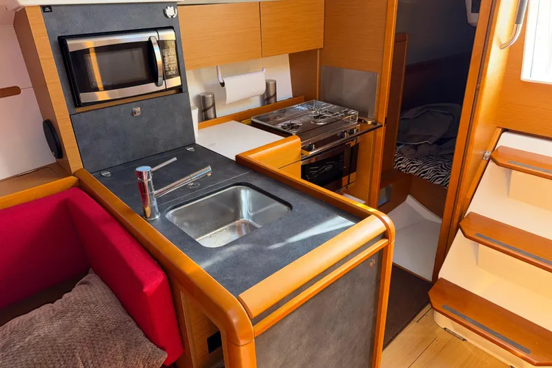 Slide: The Image of Interior of 2015 Jeanneau Sun Odyssey 349 yacht kitchen with sink, stove, and microwave. - 25