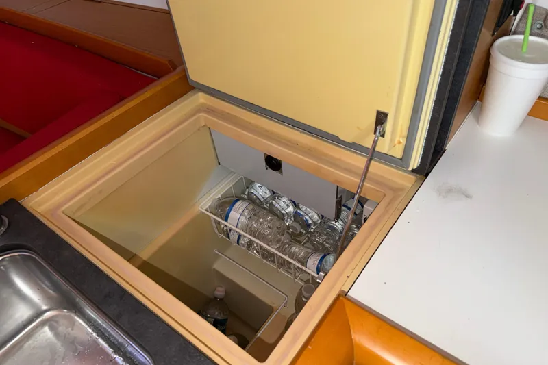 Slide: The Image of Built-in fridge on 2015 Jeanneau Sun Odyssey 349 yacht, stocked with water bottles. - 28